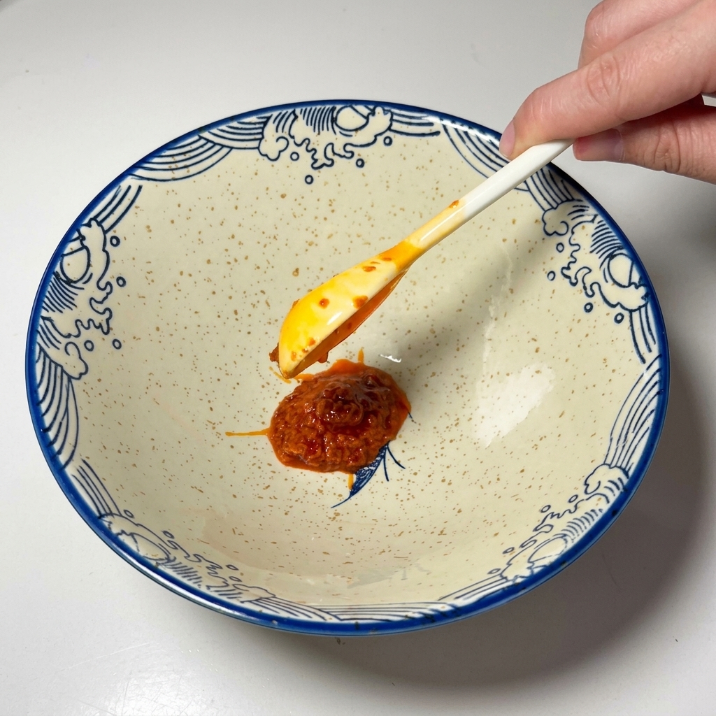 空の丼に唐辛子ペーストをのせた様子。