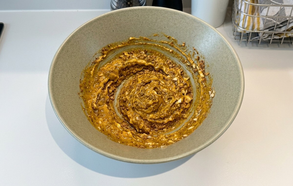器の中で調味料が混ざり合い、茶色のペースト状になっている様子。