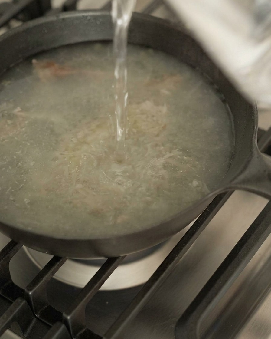 鴨肉の旨味が残ったスキレットに、水を注ぐ様子。