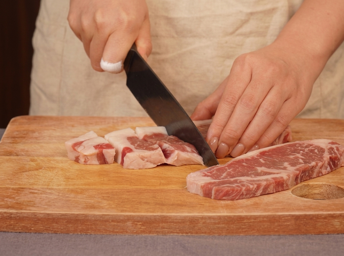 ステーキ肉を包丁で小さくカットしている様子。