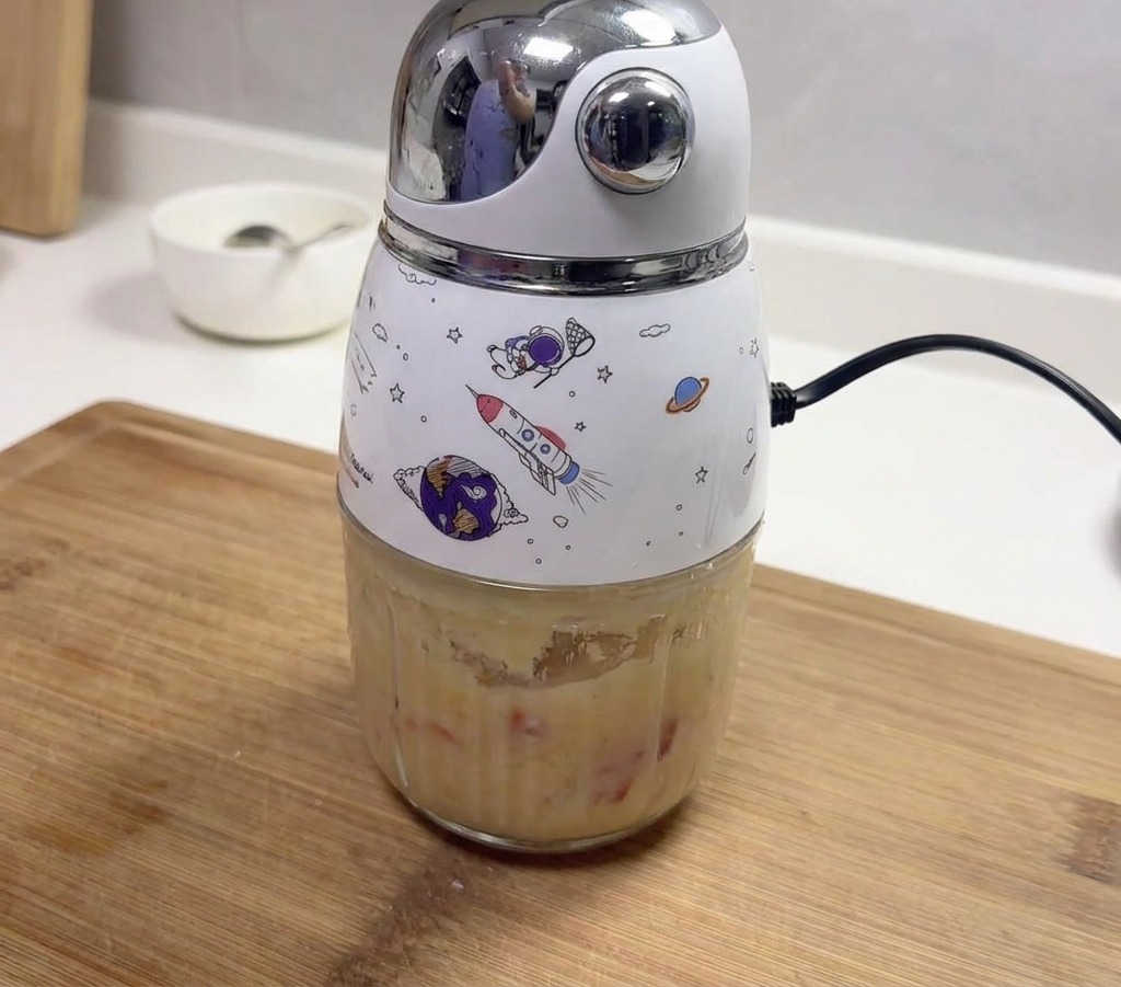 すり潰したニンニクと赤唐辛子で満たされた、宇宙をモチーフにしたイラスト入りの小さな電動ミキサー。
