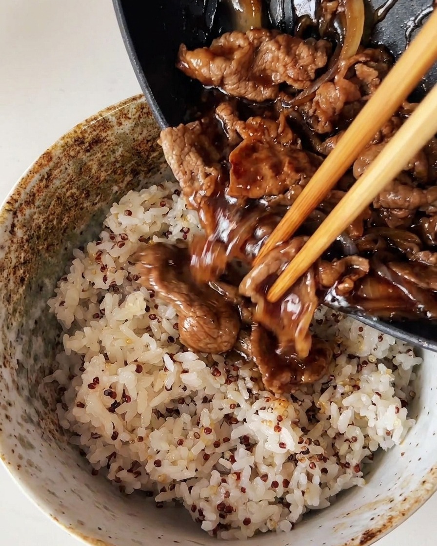 キヌアをブレンドして炊いたほかほかの白米の上に、フライパンからジューシーな牛肉と玉ねぎをたっぷりとのせている様子。