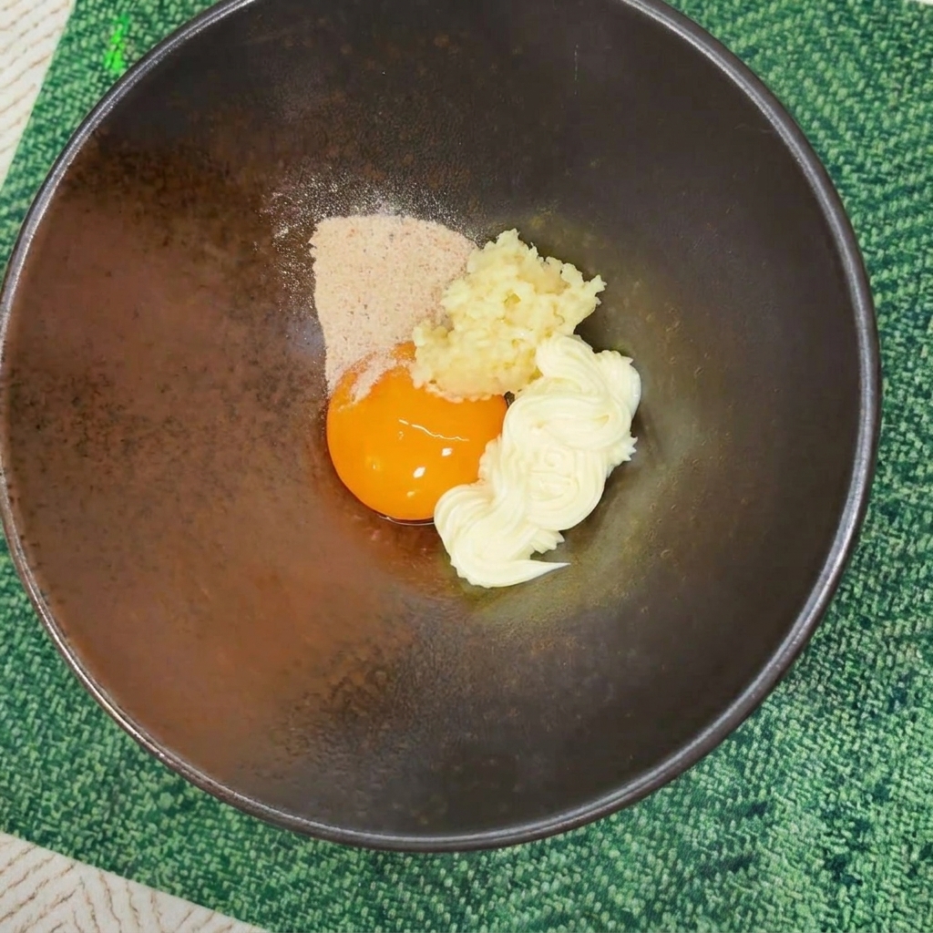 粉末スープが乗ったボウルに、乾燥野菜などのかやくが追加されている様子。