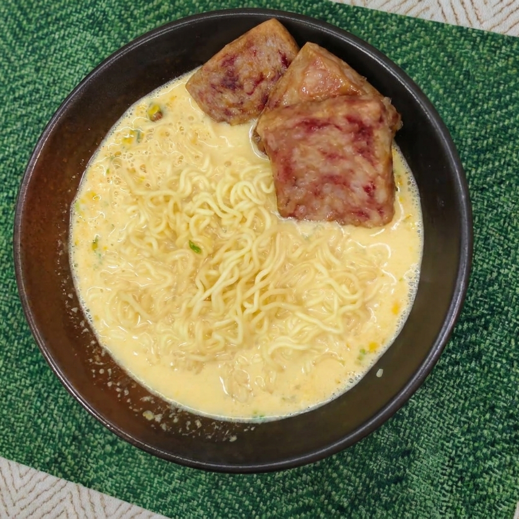 クリーミーなラーメンの上に、こんがりと焼けたスパムの切り身が並べられた様子。