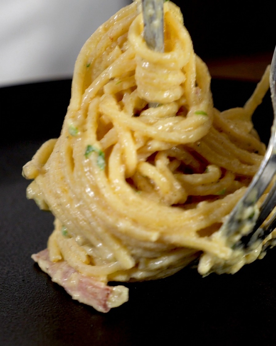 フォークを使ってパスタを高く巻き上げている様子。