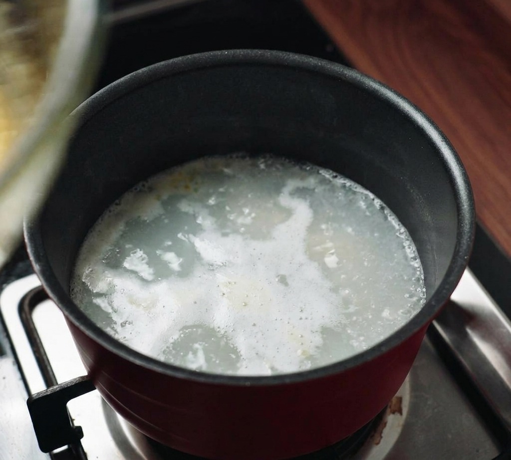 茹で汁が入った鍋の上に、ソースの入ったボウルを重ねて湯せんにかけている様子。