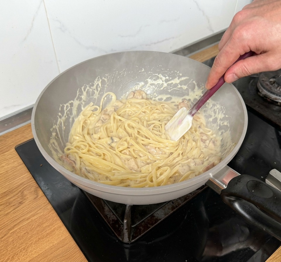 パスタとソースを素早く和え、一体化させる様子
