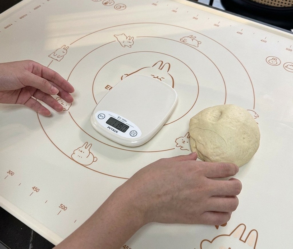 デジタルスケールの横にあるシリコンマットの上に、小さく分割された生地が置かれている様子。