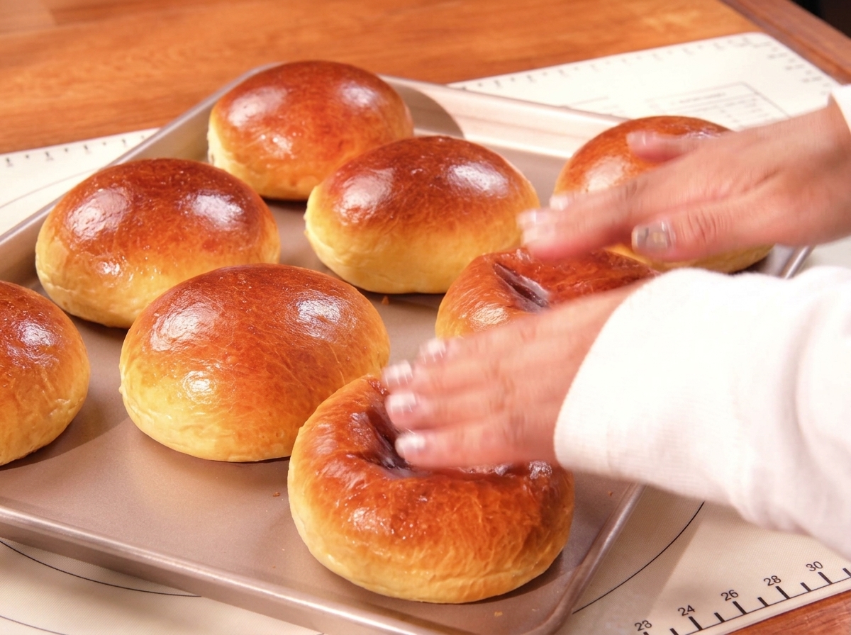 焼き上がったツヤツヤの黄金色のバンズが天板に乗っている様子。