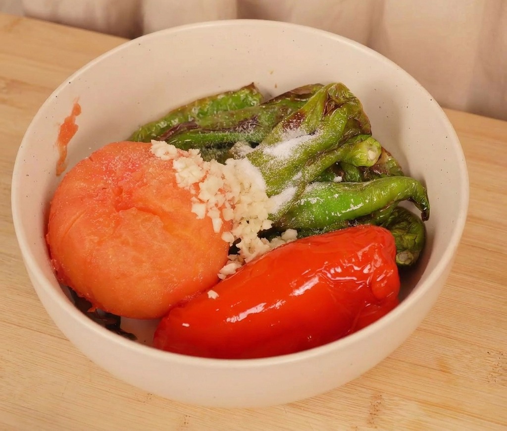 ローストした野菜が入ったボウルに、おろしにんにくと塩を加え、混ぜ合わせる前の様子。