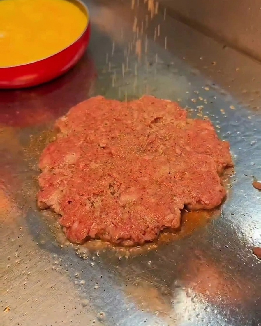 焼いている肉に塩こしょうを振る様子