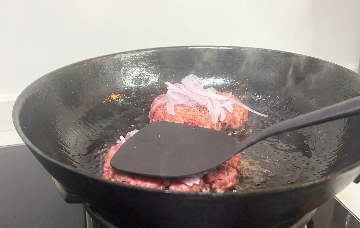 フライ返しでパティを強く押し潰す様子