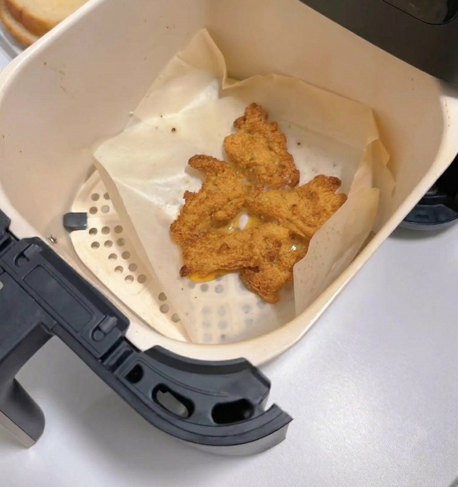 エアフライヤーから引き出された、こんがりと黄金色に焼き上がった熱々の唐揚げ。