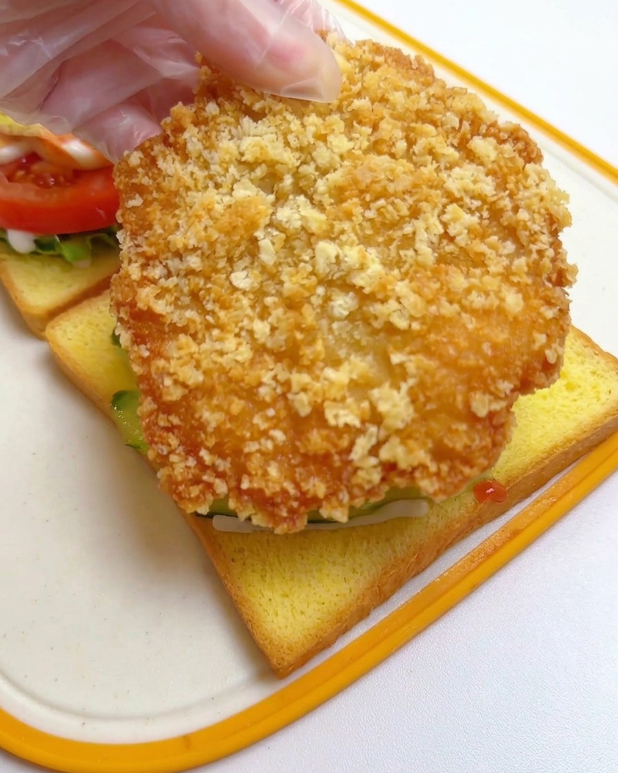 きゅうりの上に揚げたての鶏カツを大胆に乗せている様子。