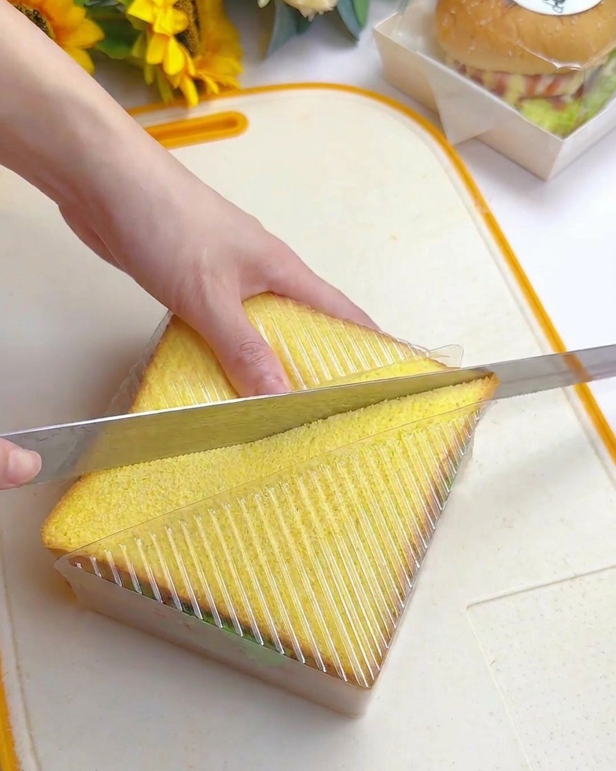 ケースに入れたまま、パン切り包丁で斜めにカットしている様子。