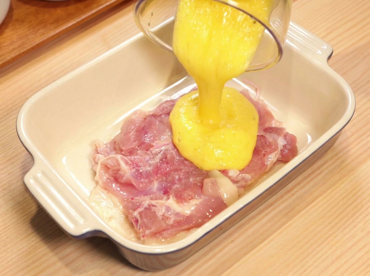 鶏もも肉にパイナップルジュースをかけている様子