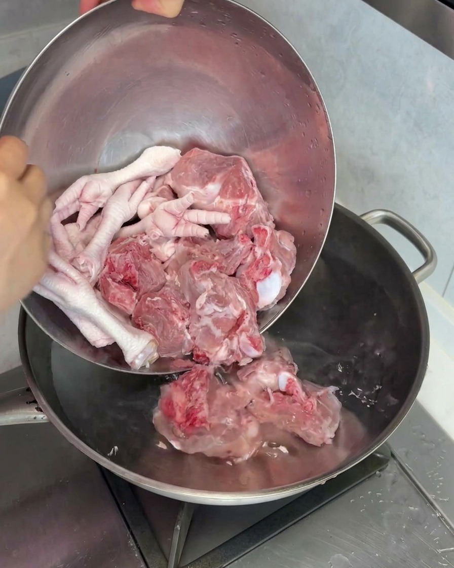 豚げんこつと鶏もみじを鍋に入れて下茹でする様子。