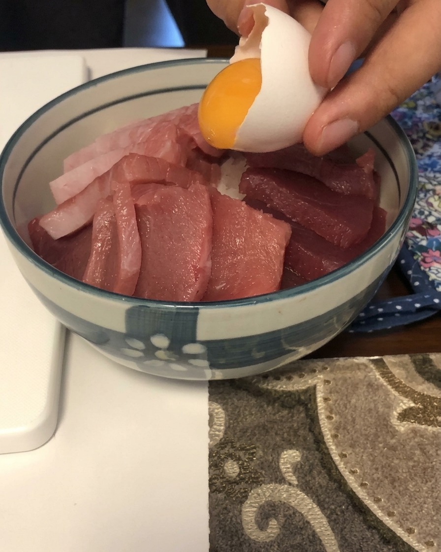 マグロの上に新鮮な卵黄をそっと乗せている様子。