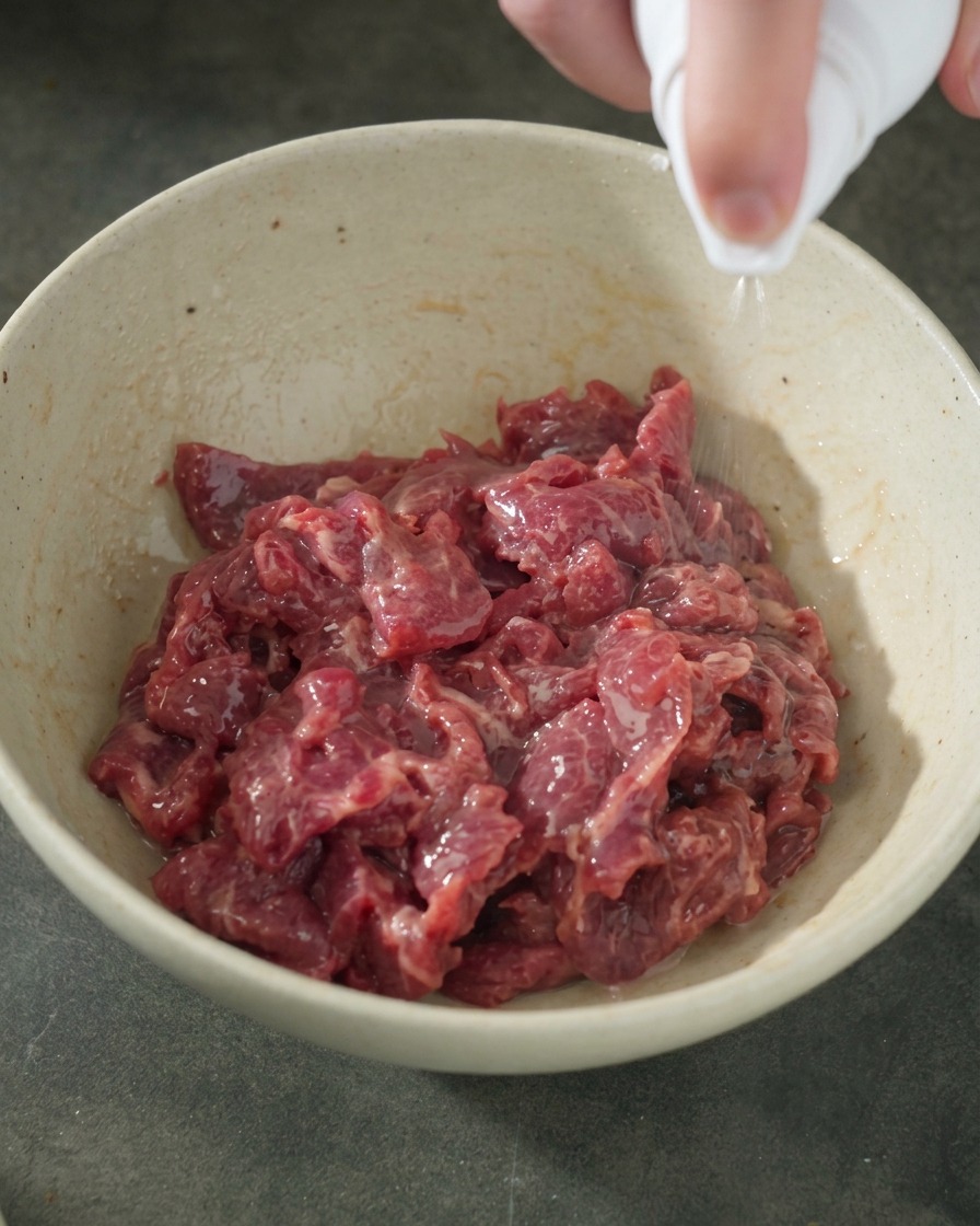 オイルをスプレーして、牛肉の表面に艶を出している様子。