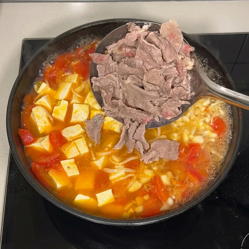 穴あきお玉を使って、湯通し済みの牛肉をスープに戻している様子。