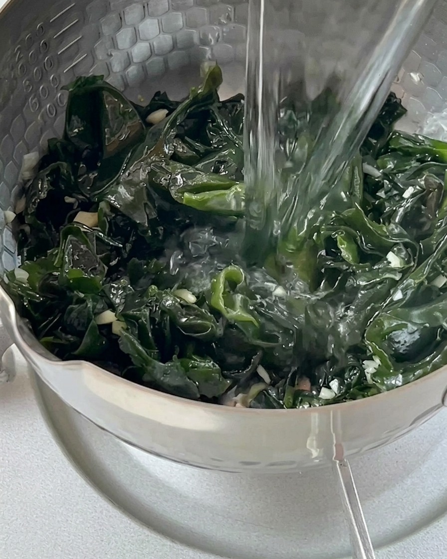 ケトルからわかめを入れた鍋に熱湯を注いでいる様子
