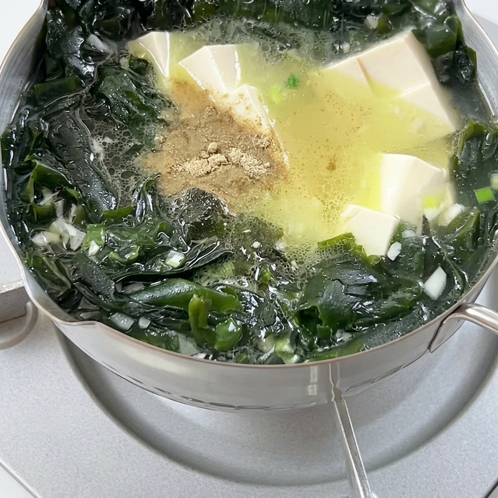 鍋に白胡椒を振りかけている様子