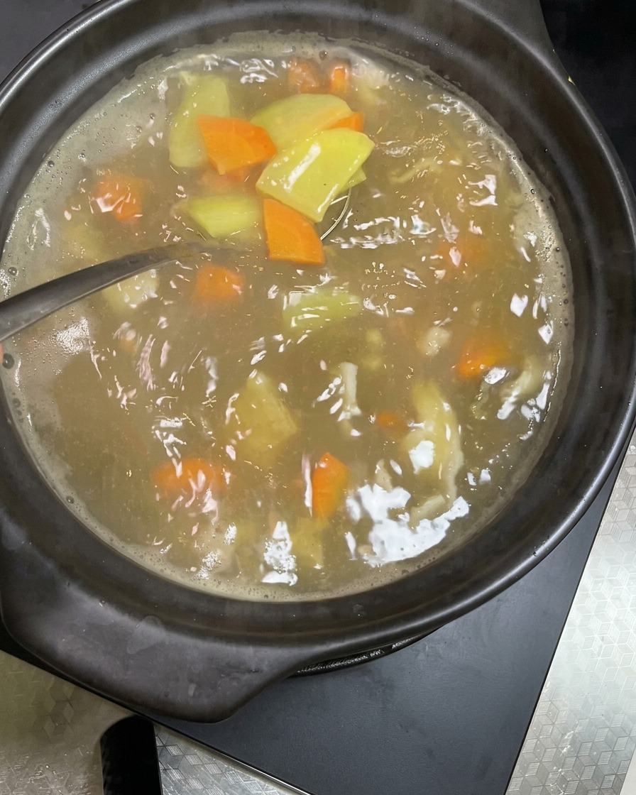 沸騰している豚肉と野菜のスープに、新鮮でシャキシャキの豆もやしを入れている様子。