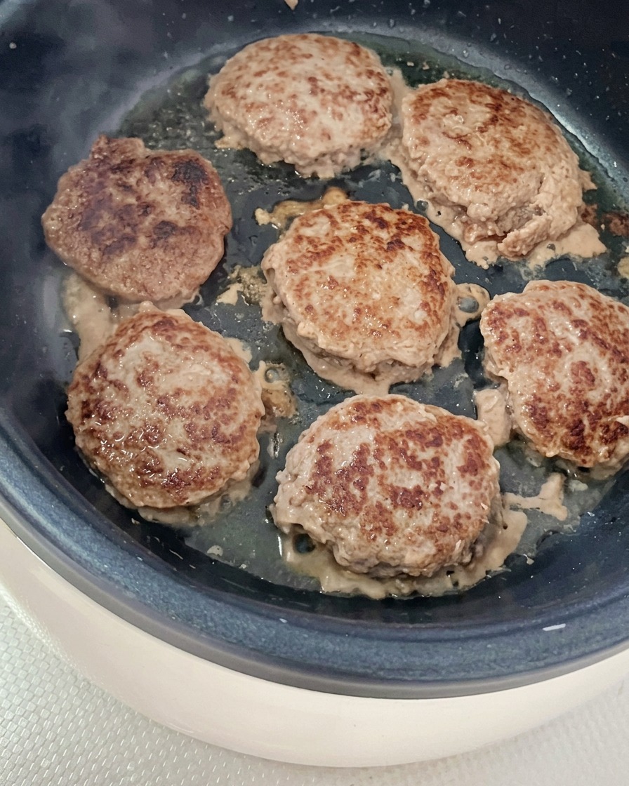 フライパンに油をひき、丸めたビーフパティを焼いている様子