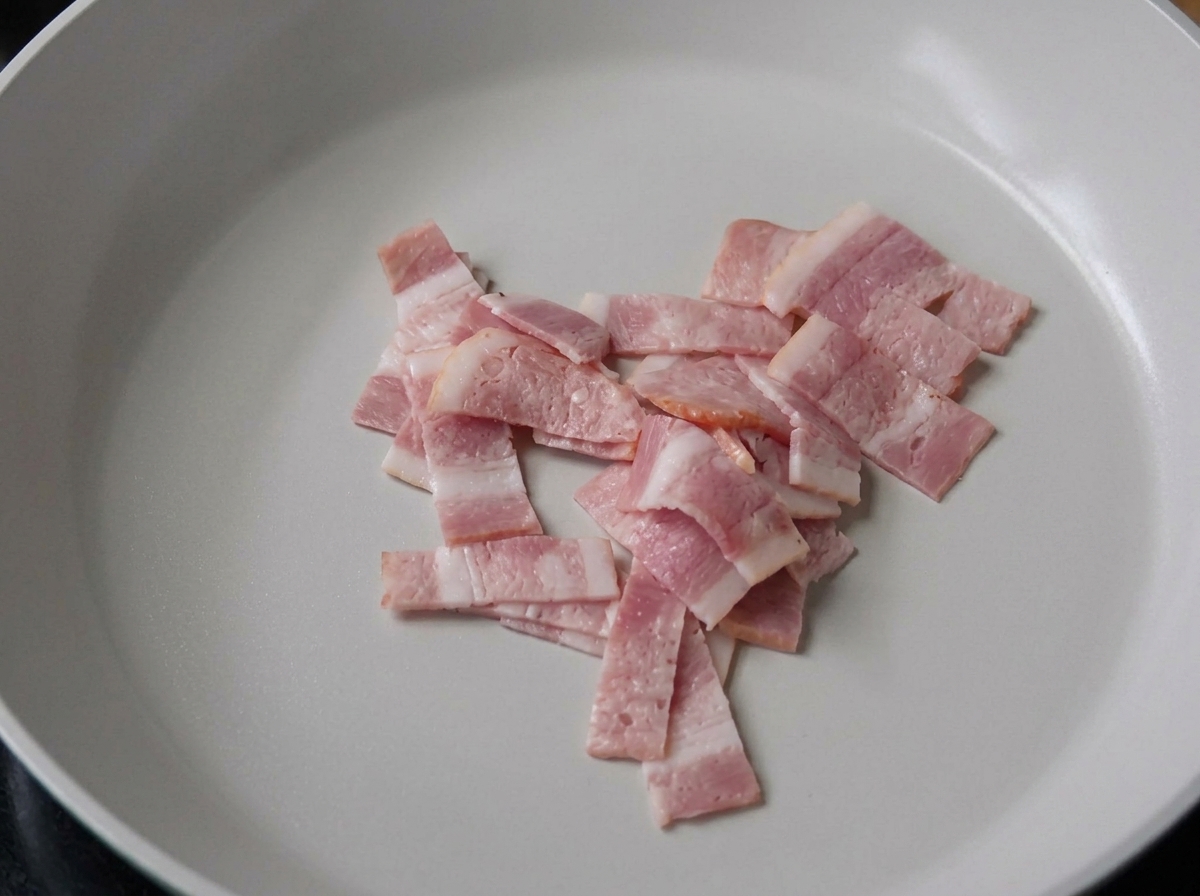 フライパンでベーコンをカリカリに焼いている様子。