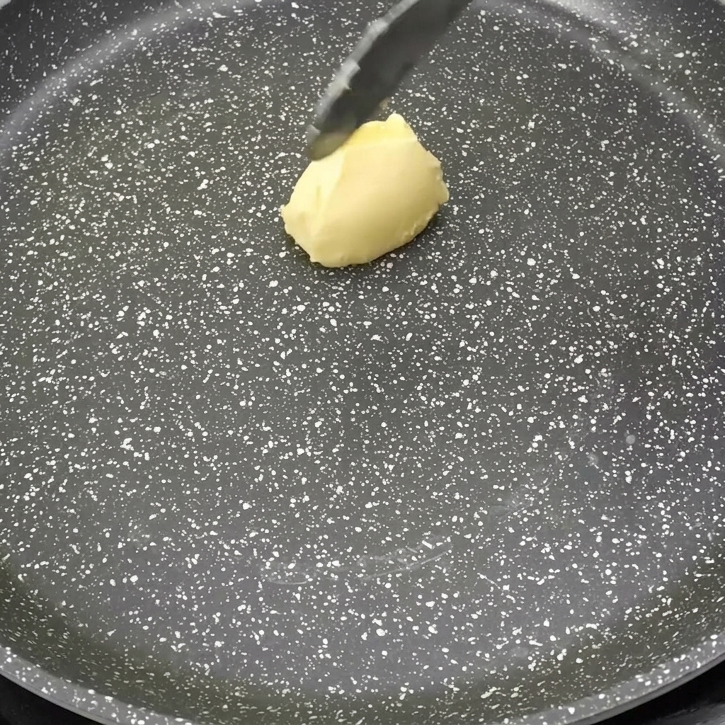 熱したフライパンの上でバターが溶けて泡立っている様子。