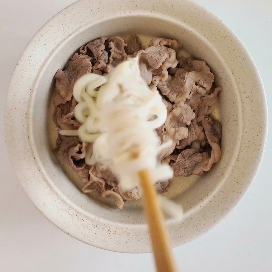 器に盛り付けられた冷たいうどんと牛肉、トマトソース。