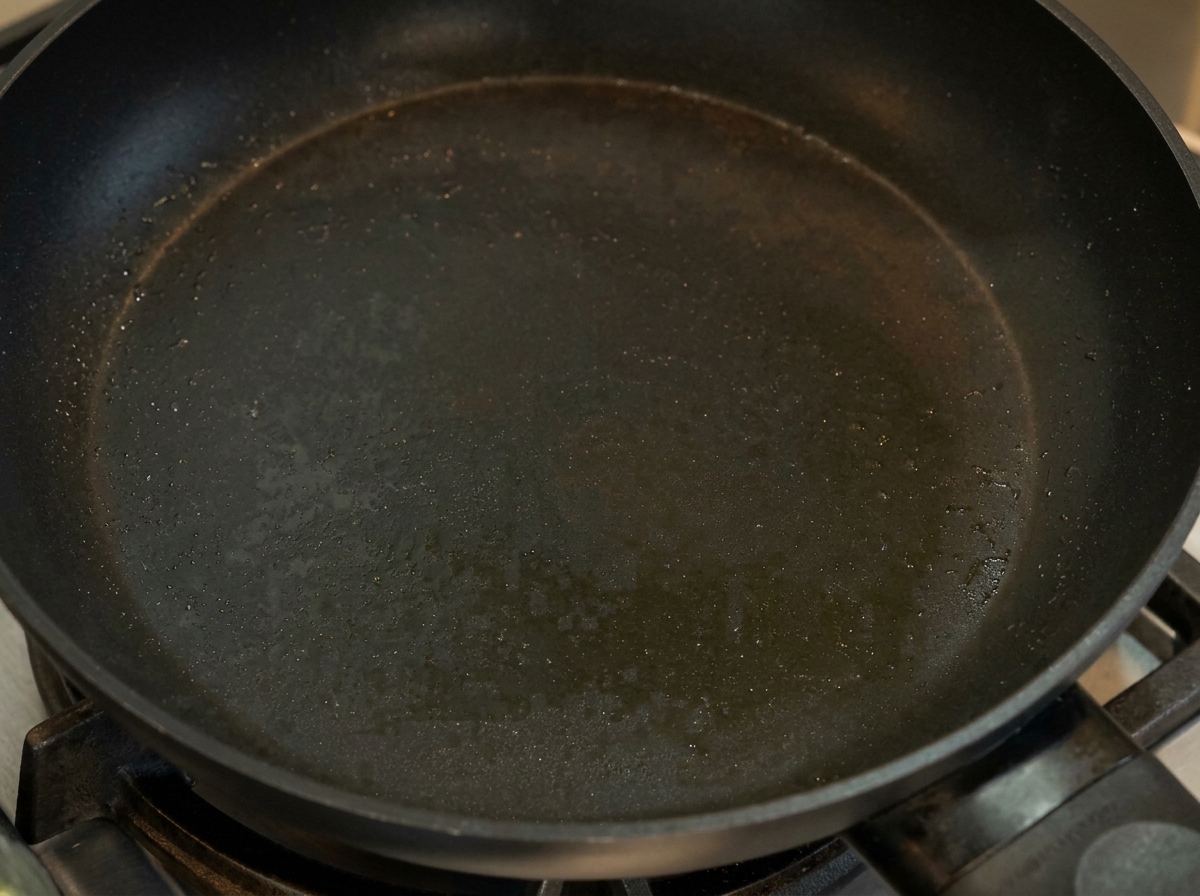 フライパンで薄く焼いた卵を折り畳んでいる様子。
