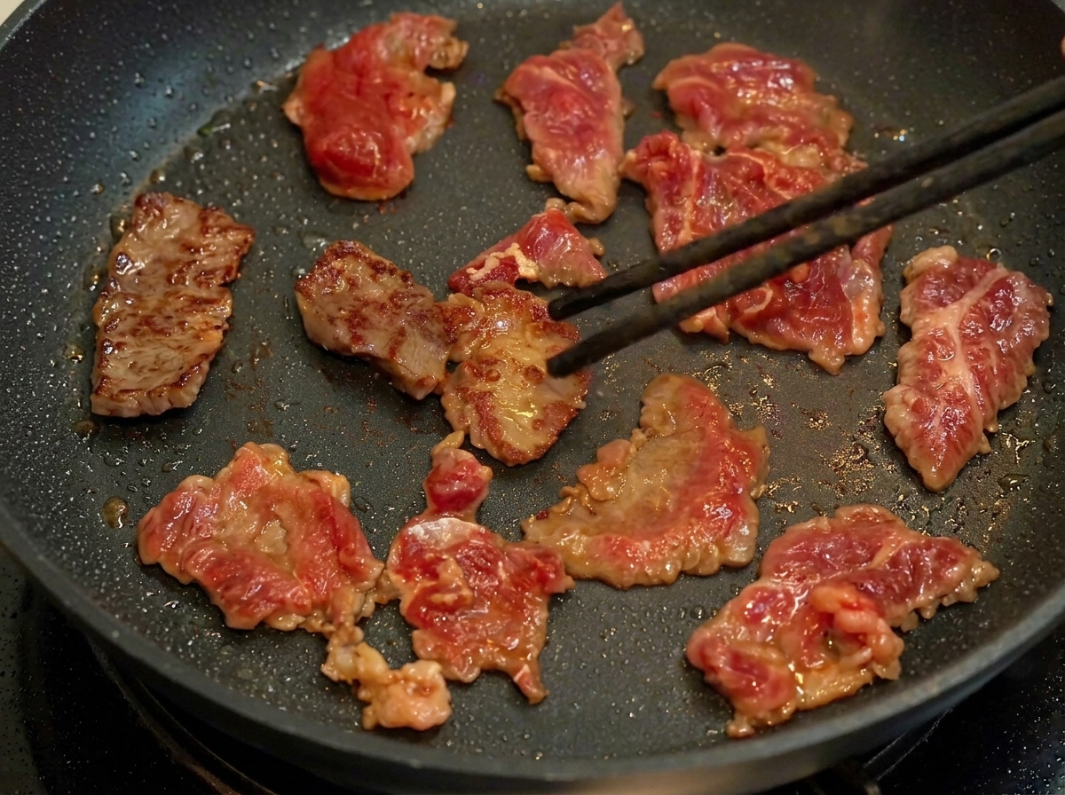 フライパンで下味をつけた牛肉を焼いている様子。