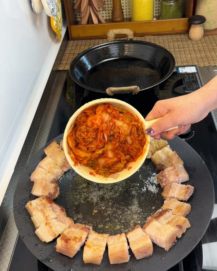 円状に並べられた豚バラ肉の中央にキムチが置かれている様子。