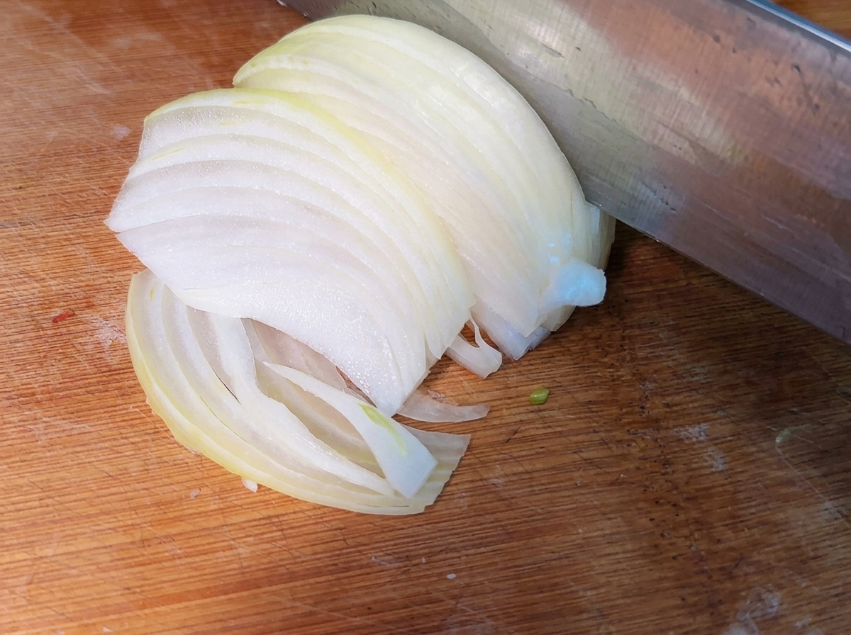 まな板の上に重ねられた薄切り玉ねぎ。