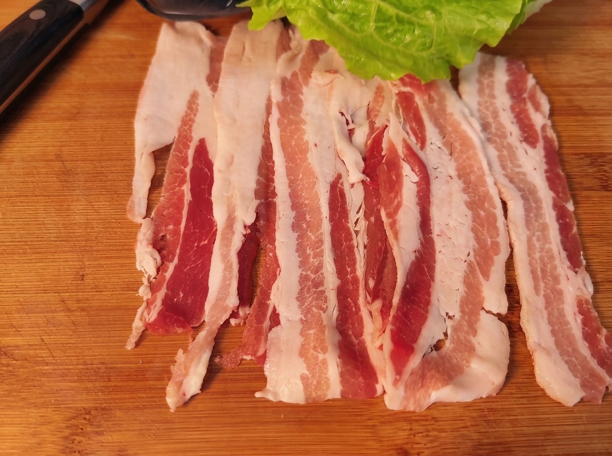 豚バラ肉の上にレタス、人参、玉ねぎ、キムチがのり、巻く直前の状態。
