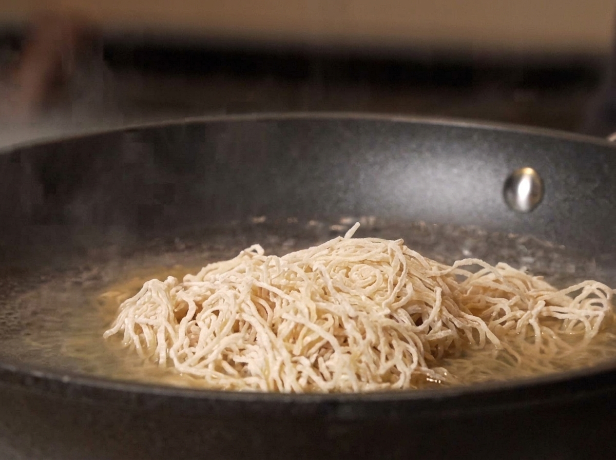 沸騰したお湯に生麺を投入している様子