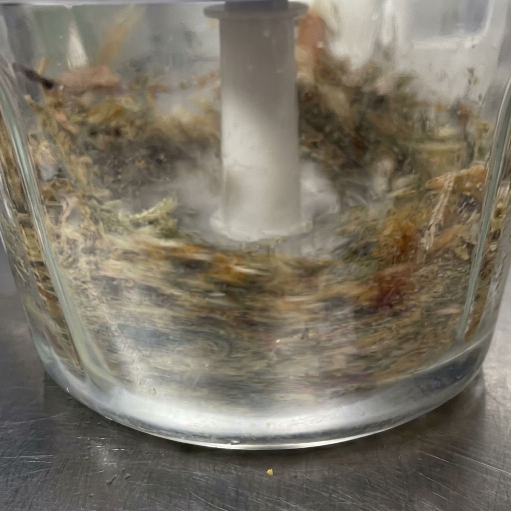 鍋の中のタレに、細かく砕いた魚介粉末を投入している様子。
