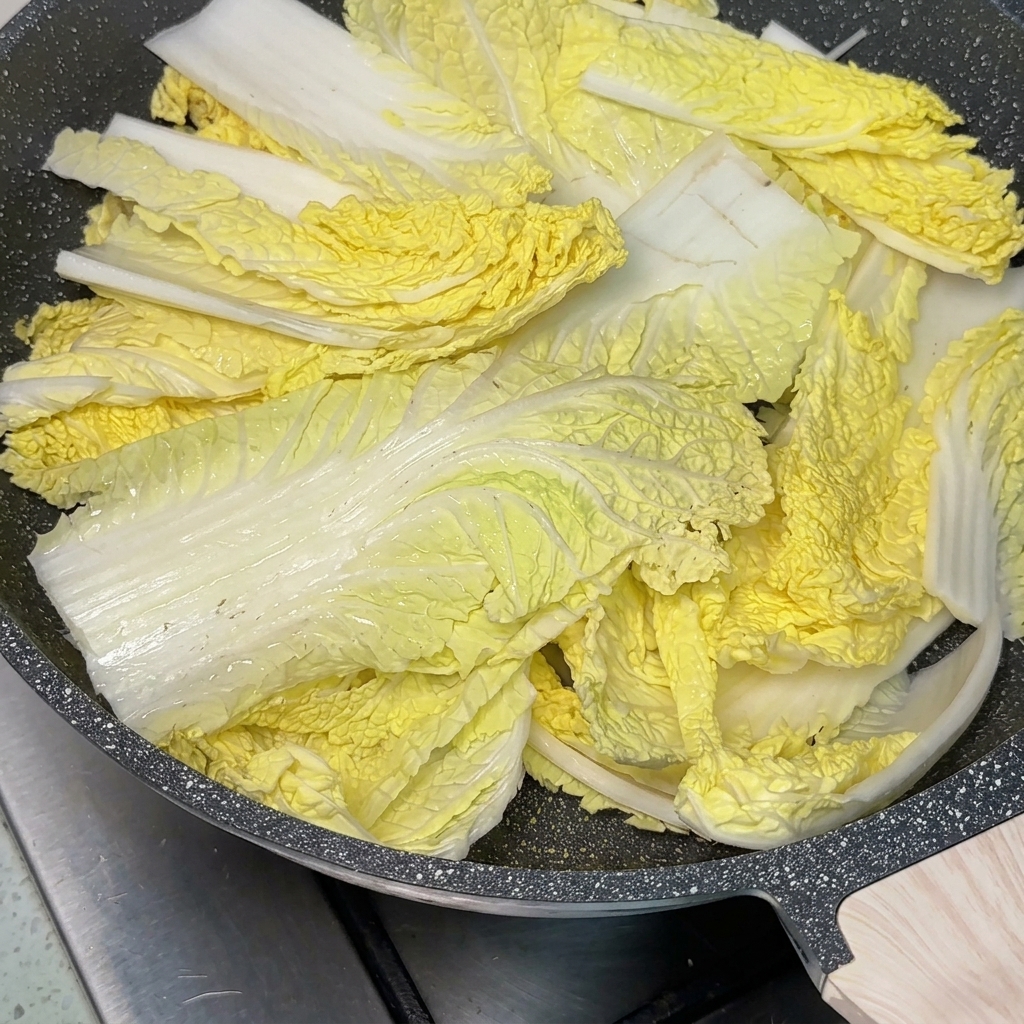 鍋の中央にコチュジャンをのせ、その周りにスープを注いでいる様子。