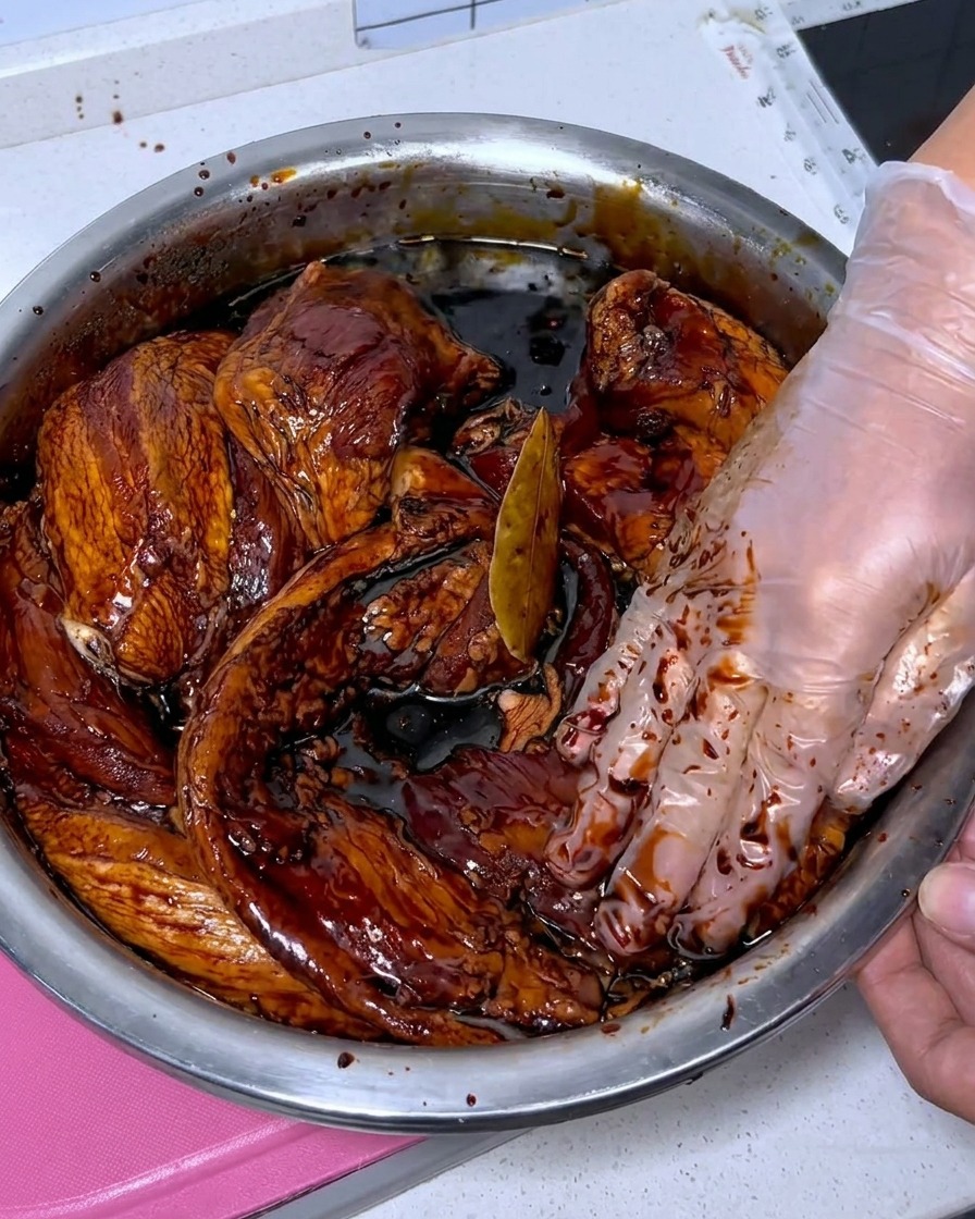 ボウルに入った豚バラ肉に白酒をかけて洗浄している様子