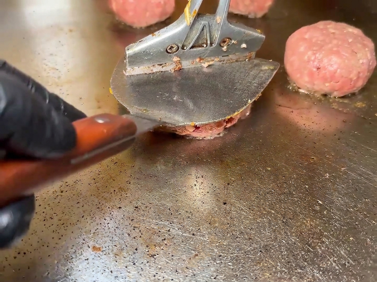 熱いグリドルで焼かれているビーフパティ。