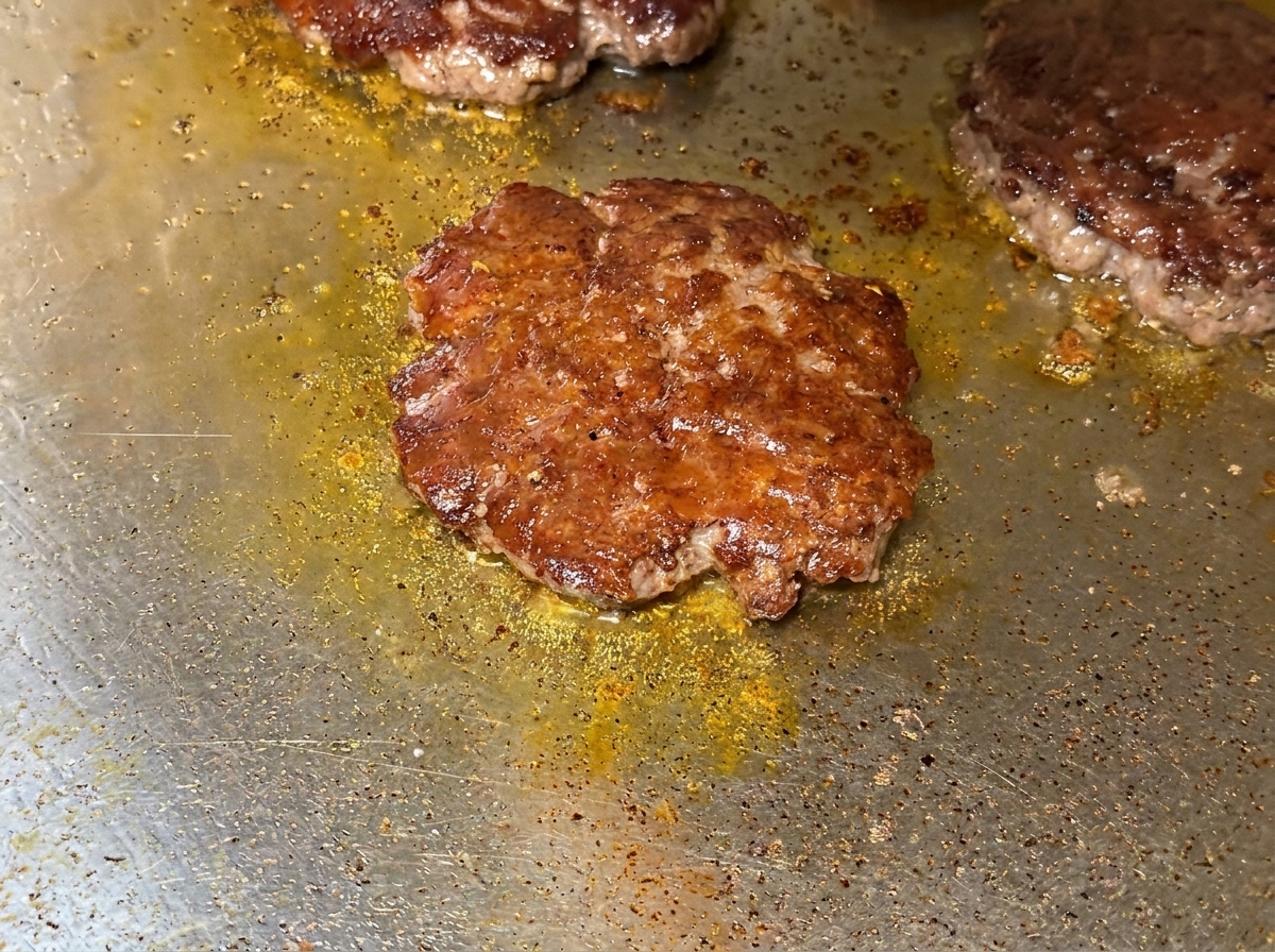 焼いたビーフパティの上でとろけているチェダーチーズ。