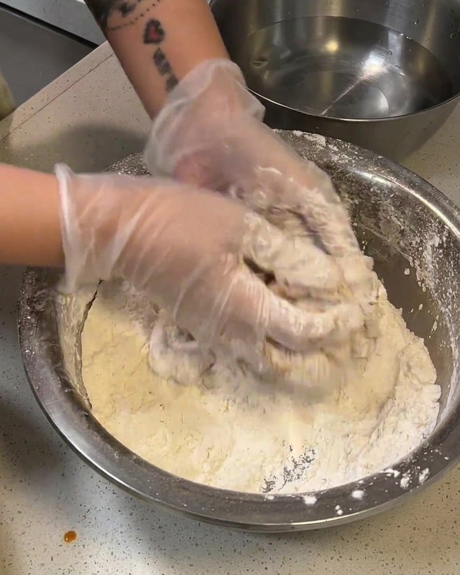 粉をつけた鶏肉を水にさっとくぐらせている様子。
