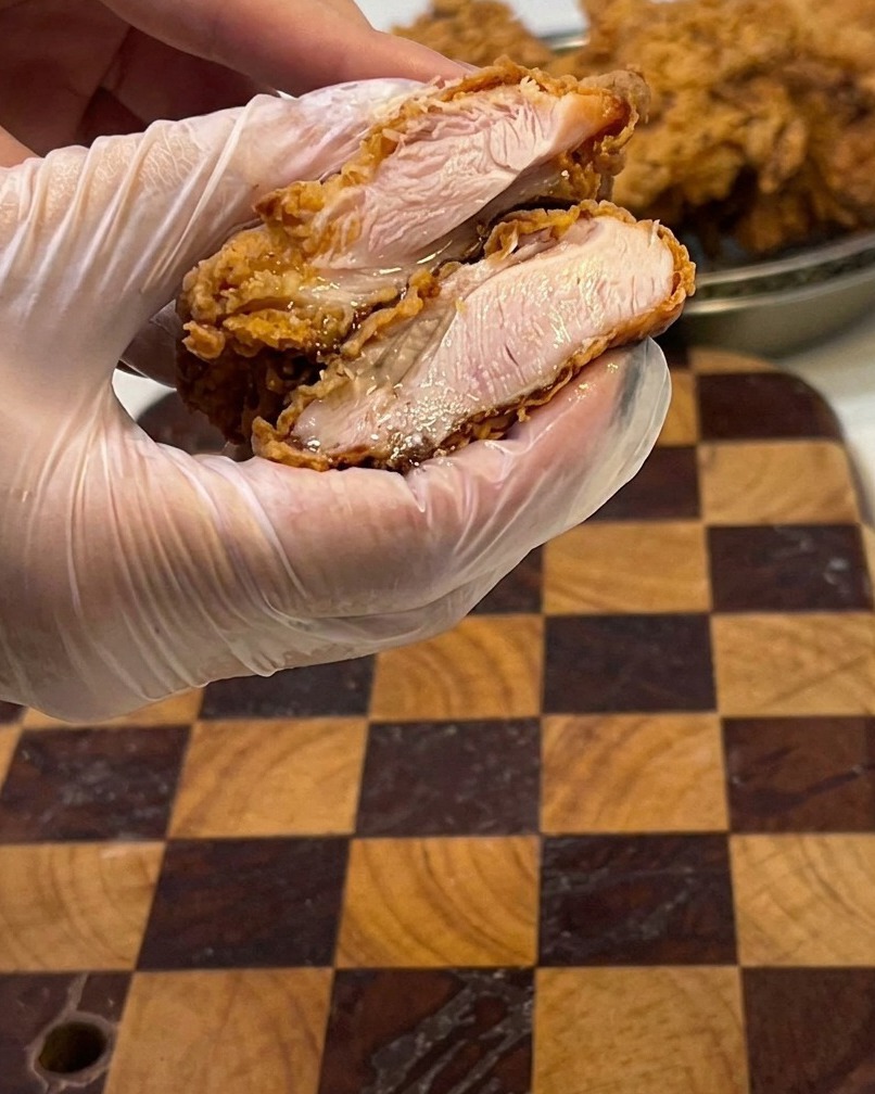 揚げたてのチキンを切った断面、肉汁溢れる様子。