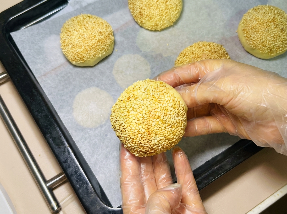 クッキングシートを敷いた天板に生地を並べる様子。