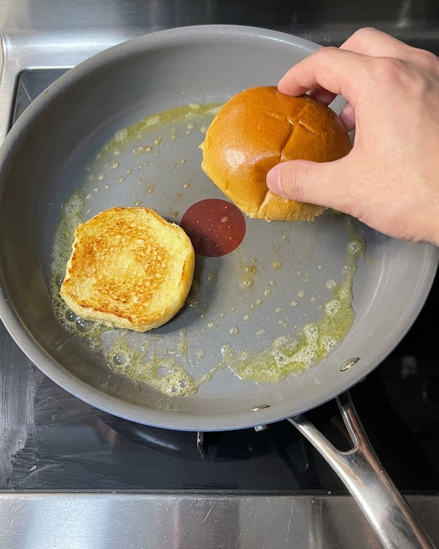 バターを溶かしたフライパンでバンズの断面を焼いている様子。