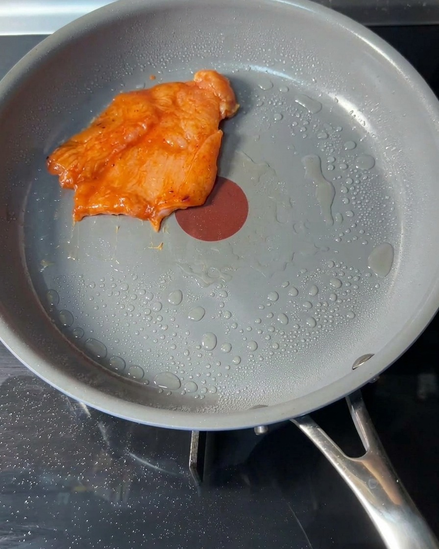 熱したフライパンに漬け込んだチキンを並べている様子。