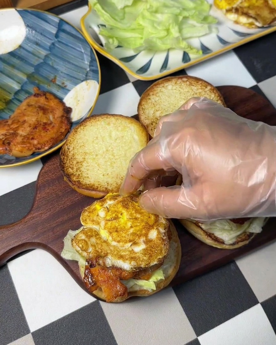 チキンの上に焼きたての目玉焼きをのせている様子。