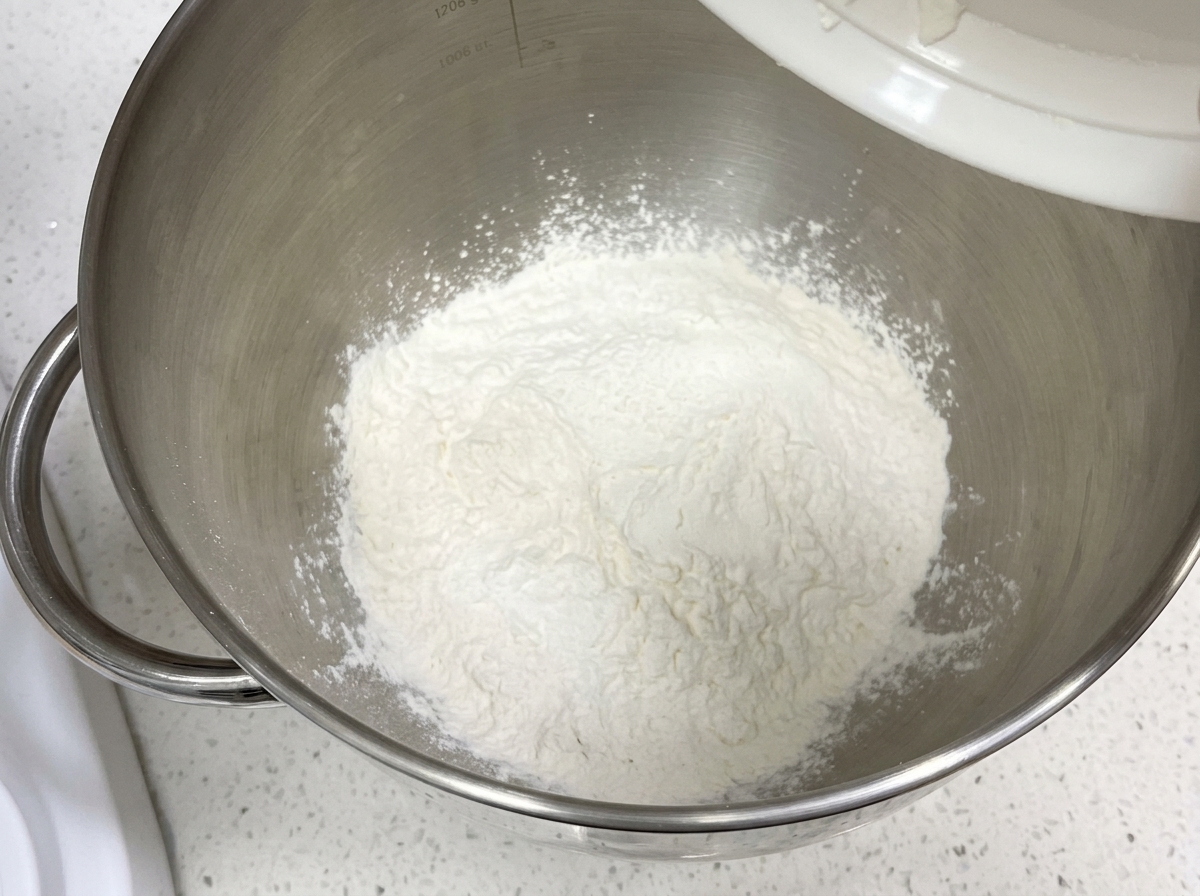 スタンドミキサーのきれいなボウルに入った小麦粉などの乾燥材料。