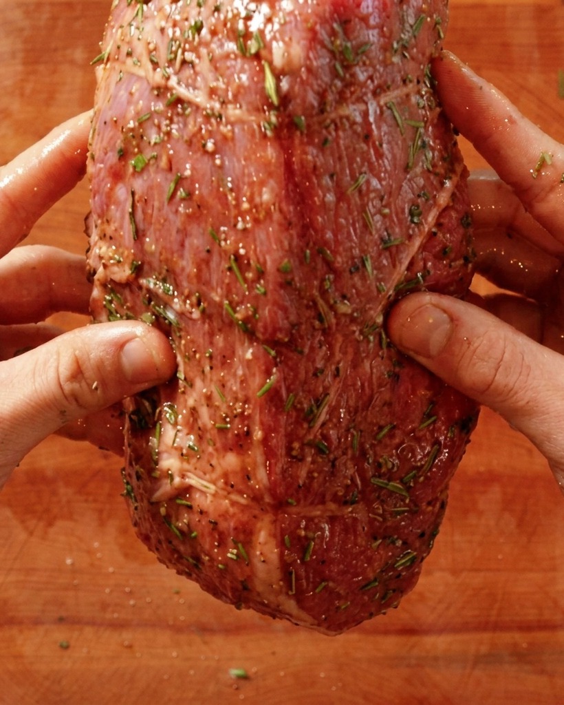 熱したフライパンに牛肉を入れている手。